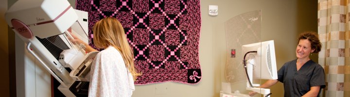 Mammographer Holly Blue screens a woman for breast cancer.